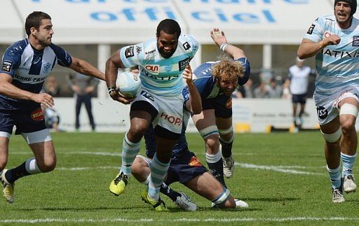 Racing Metro fly-half Masi Matadigo breaks past Castres' Remi Tales (L) and Antonie Claassen (2nd R) on May 4, 2013